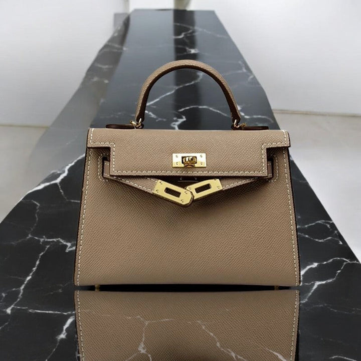 Fashionable structured top handle handbag for women, enhanced with a sophisticated gold lock detail.