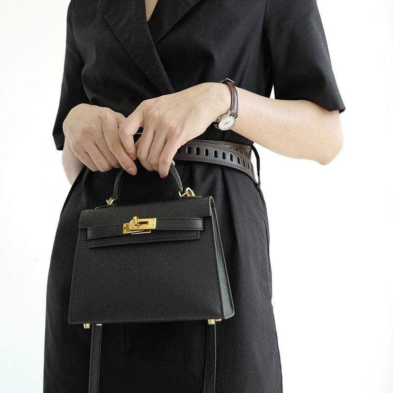 Stylish women's day bag: structured, top handle design, and elegant gold lock closure. A chic accessory.