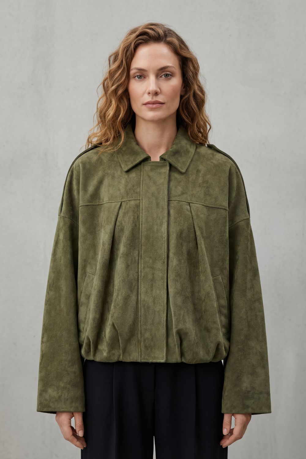 Stylish olive structured volume bomber jacket for women, a versatile outerwear piece for modern casual or elegant outfits.