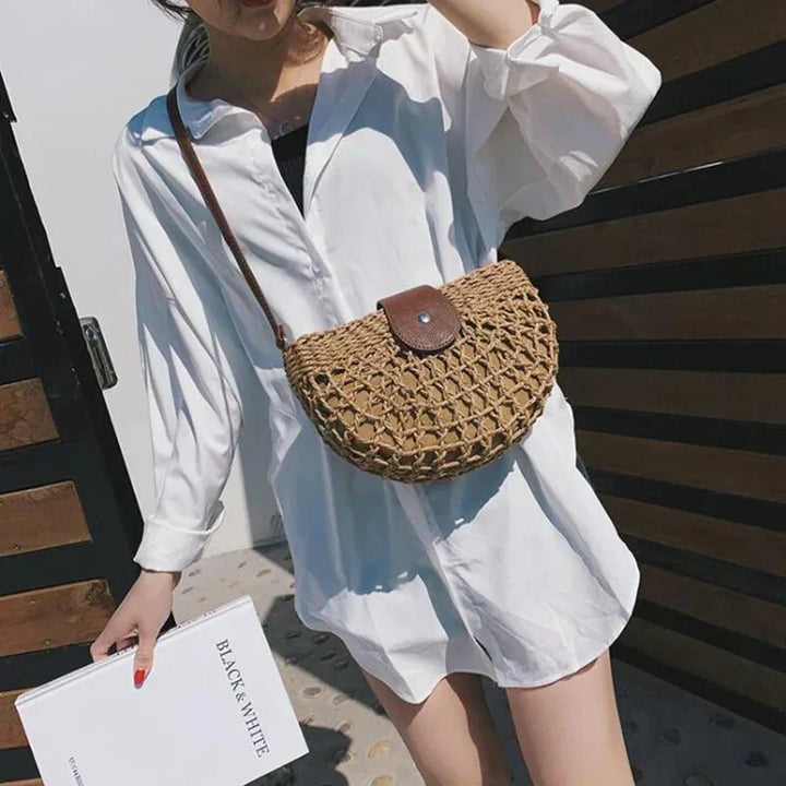 Lightweight women's braided straw handbag, perfect as a crossbody for summer or a beach bag.
