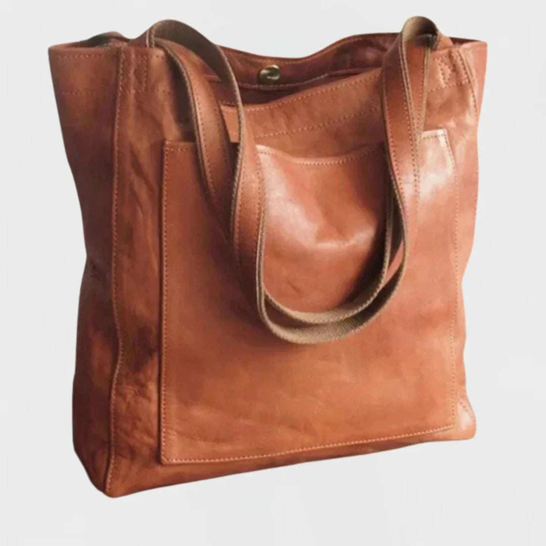 Women's stylish brown leather tote bag with front pocket, perfect for everyday carry and classic style.