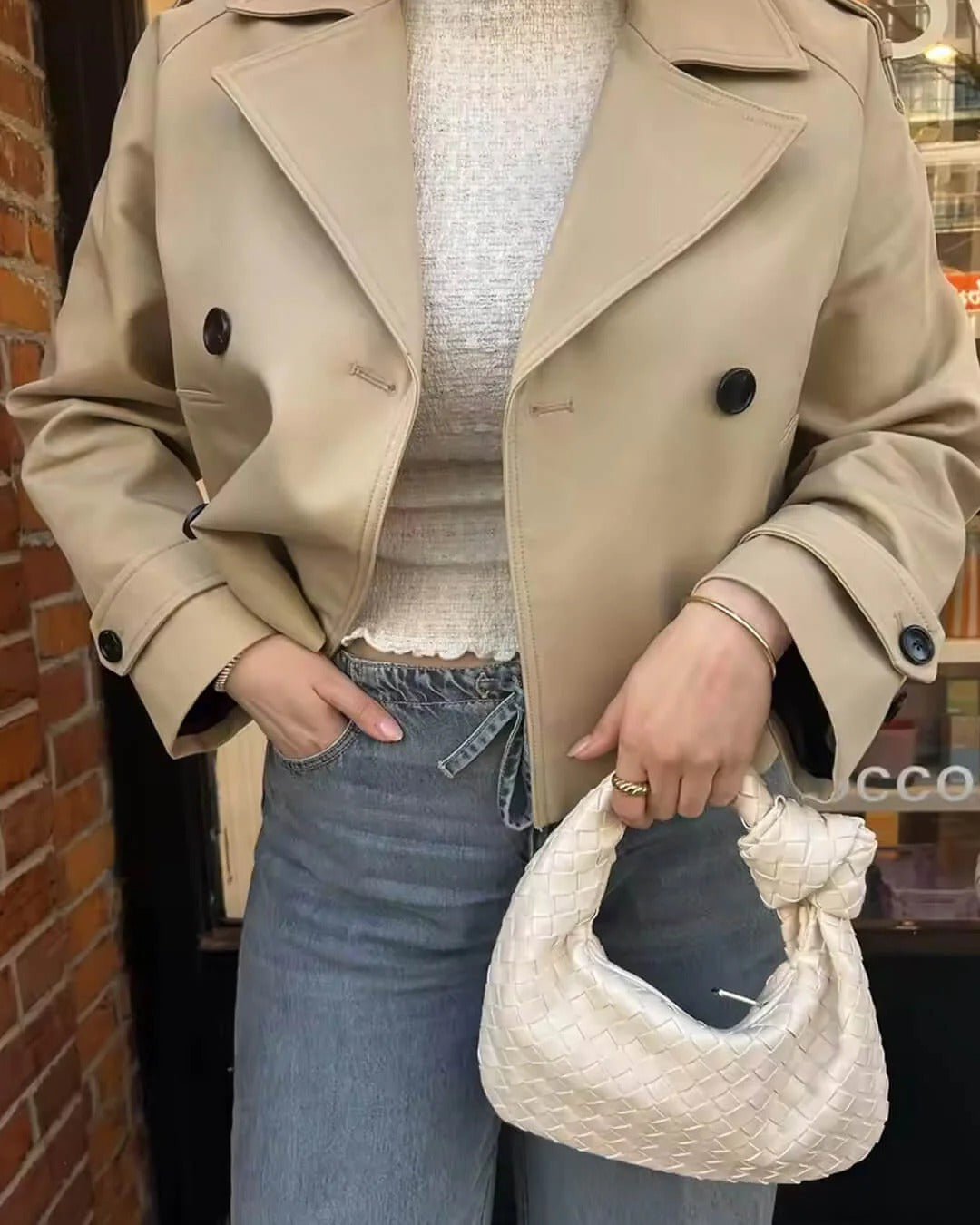 Elegant women's autumn short trench coat. Double-breasted, classic lapels, a versatile chic jacket.