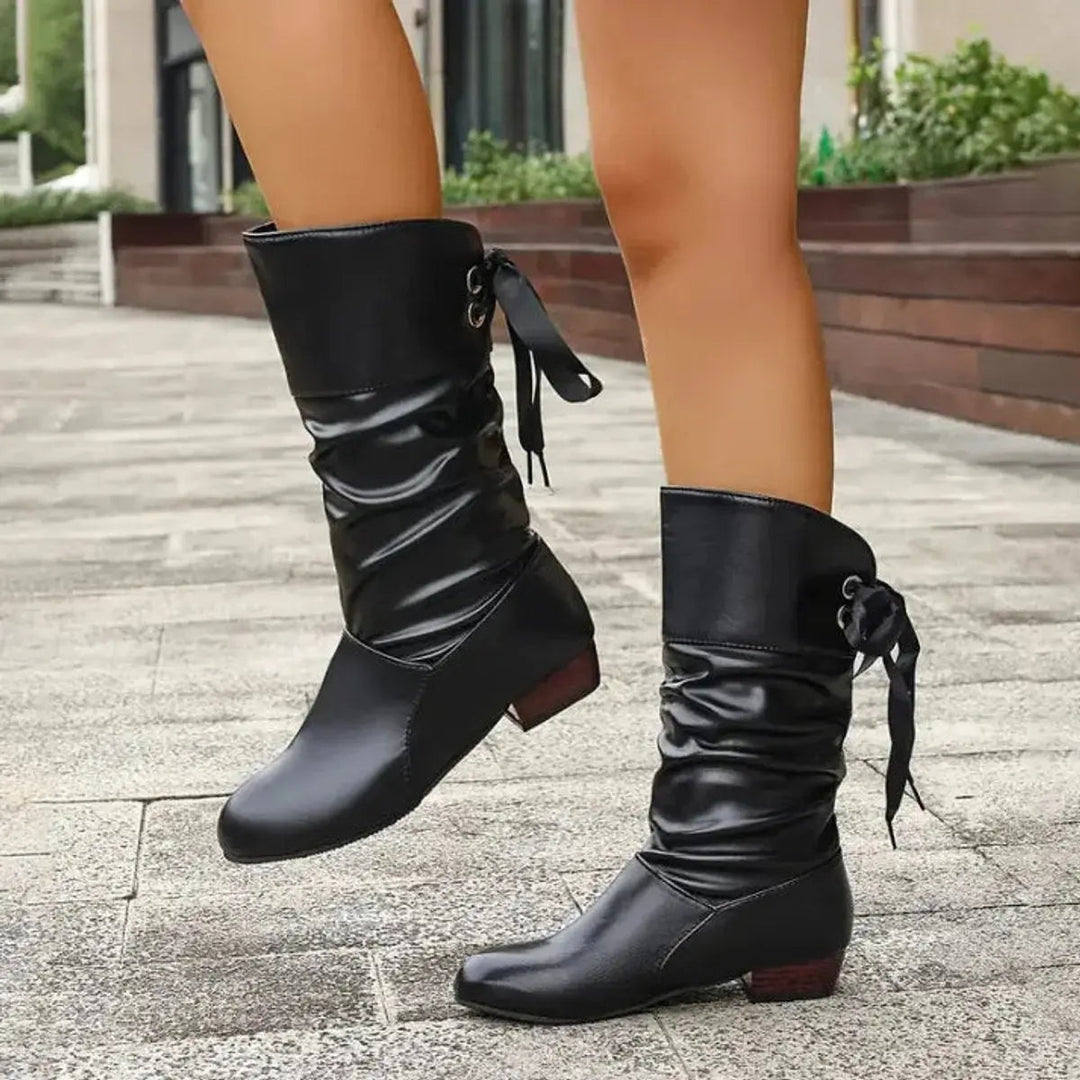 Women's mid-calf boots with decorative ribbon lace-up, ruched texture & block heel.