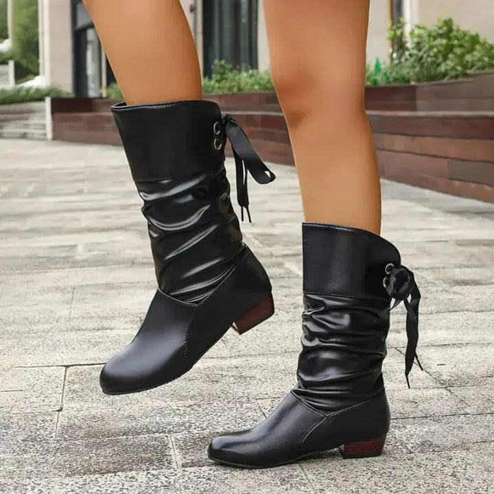 Women's mid-calf boots with decorative ribbon lace-up, ruched texture & block heel.