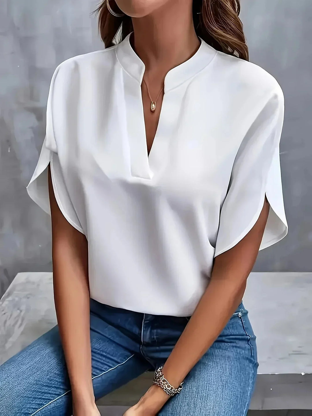 Sophisticated women's V-neck tailored blouse. Versatile short sleeve top for elegant summer fashion.