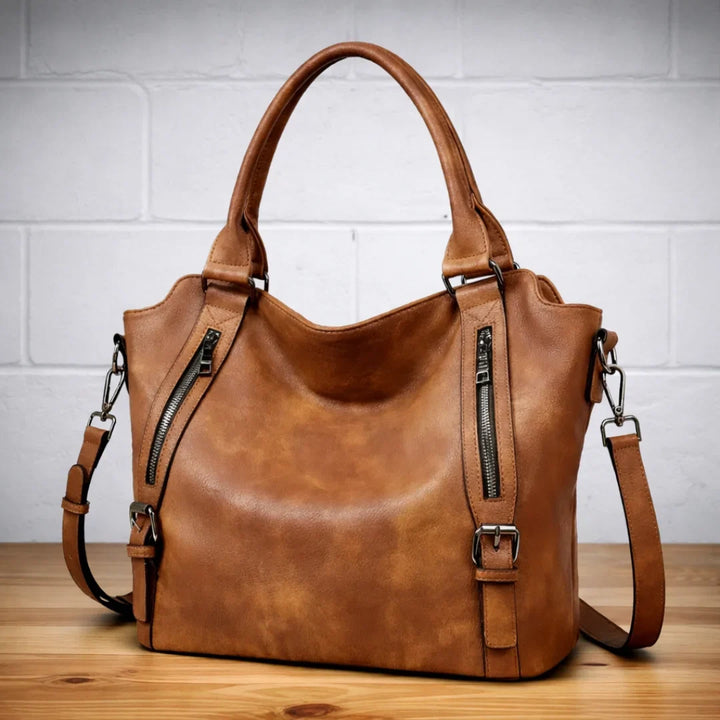 Women's tan faux-leather slouchy crossbody bag with dual zipper pockets & adjustable strap.