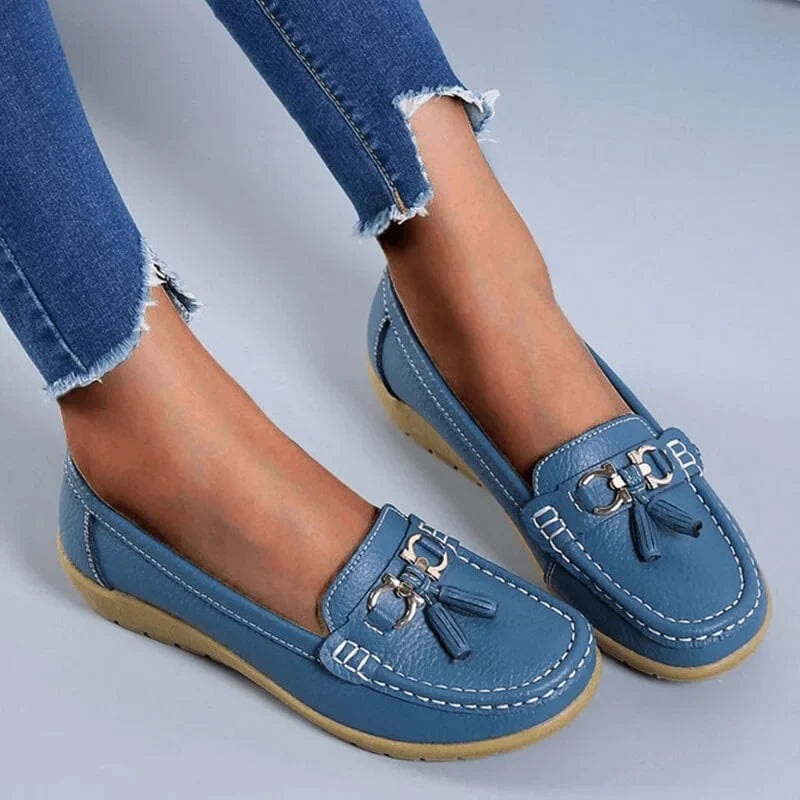 Women's tassel loafers with gold buckle & moc toe design. Stylish slip-on flats for smart casual wear.