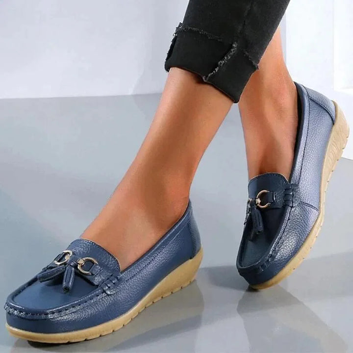 Elegant women's tassel loafers featuring a gold buckle, moc toe, and comfortable flat design.