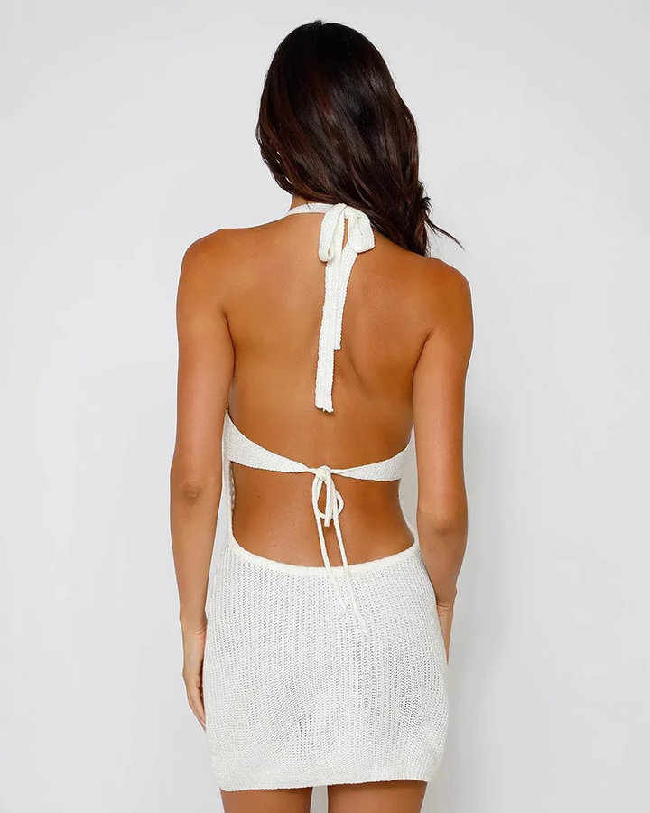 Stylish sleeveless women's mini dress featuring a halter neck, intricate open-work texture, and tie front detail.