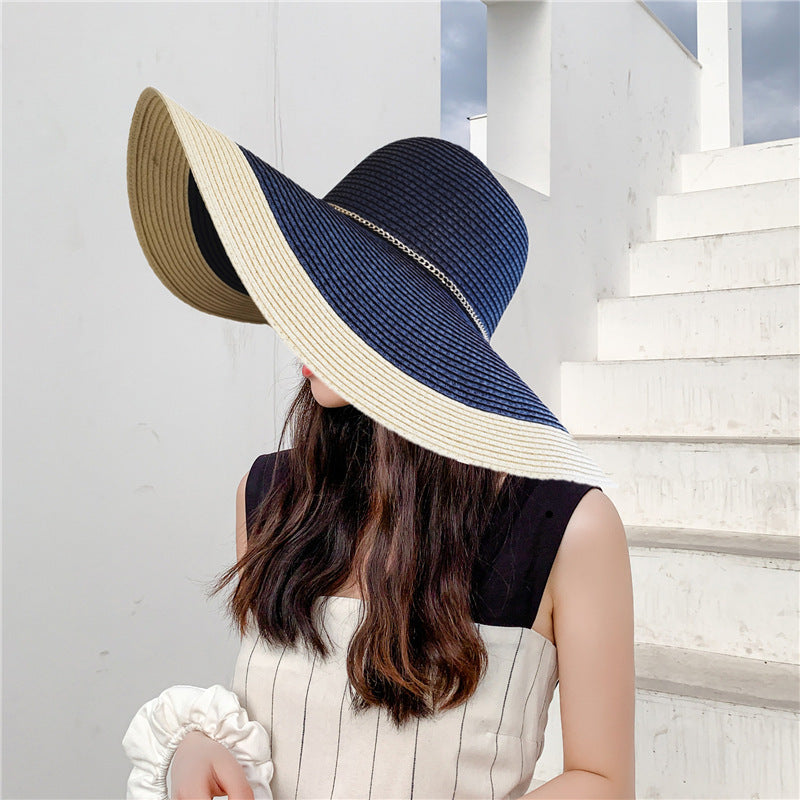 Stylish women's wide brim straw sun hat, two-tone design. Essential summer accessory for sun protection.