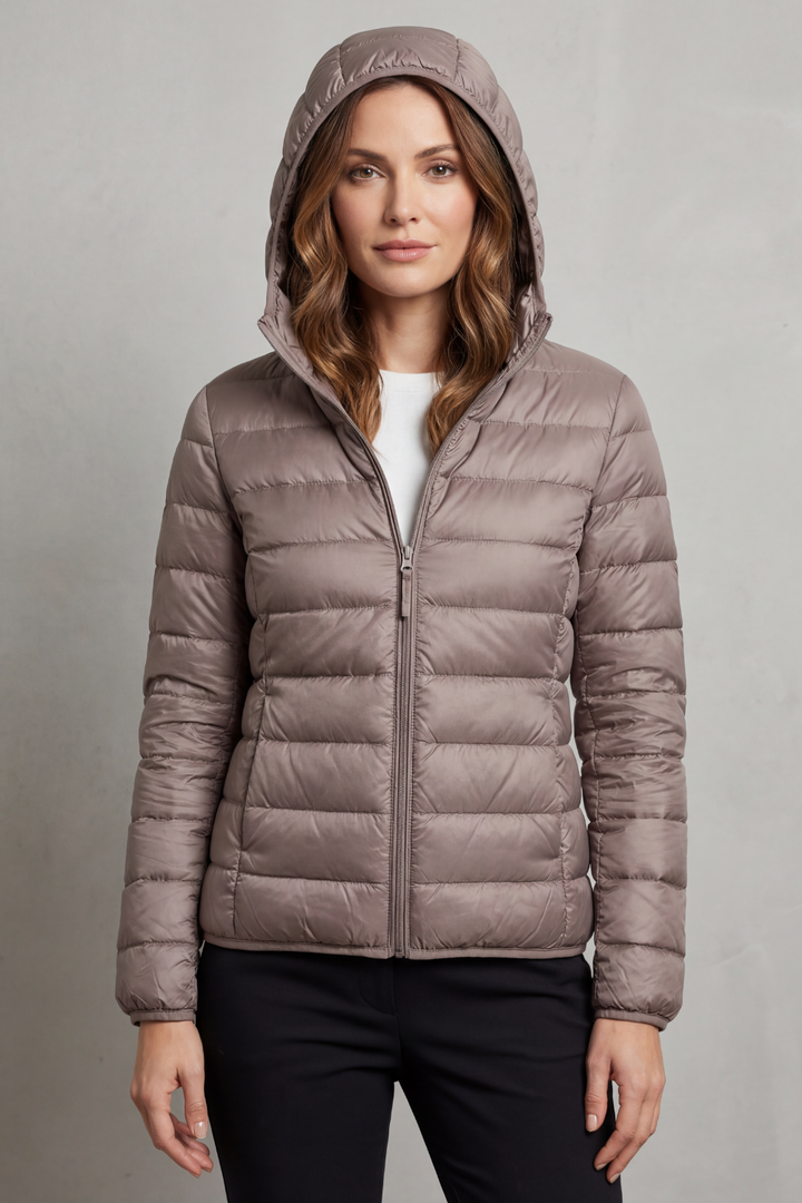 Lightweight women's puffer jacket with hood, packable design for easy travel & everyday wear.