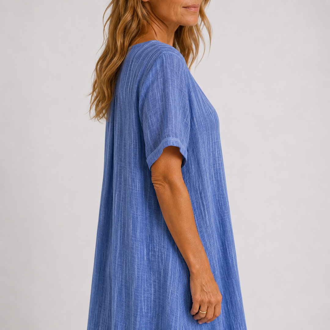 Woman modeling a flattering V-neck flowy maxi dress with elegant rolled sleeves, ideal for summer style.