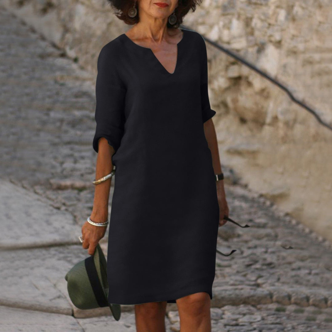 Side profile of a women's casual 3/4 sleeve V-neck midi shift dress.