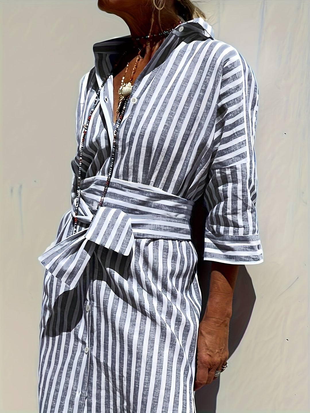 Stylish red striped button-front midi shirt dress with belt, three-quarter sleeves & split hem.