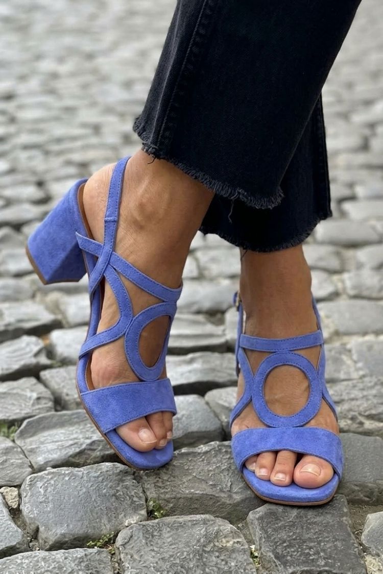 Elegant women's vibrant footwear, heeled sandals with unique circular detail.