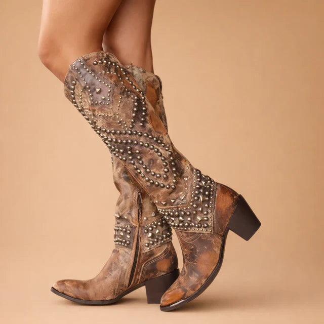 Women's vintage studded knee-high cowboy boots with chunky heel in western style.
