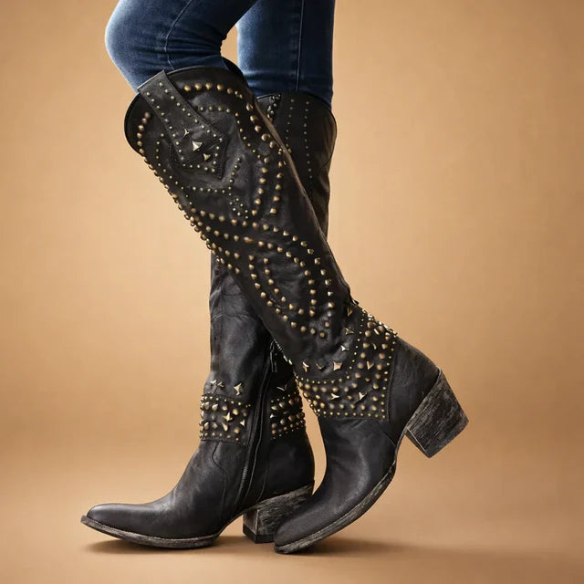 Close-up of women's vintage studded western knee-high cowboy boots, showing detail.