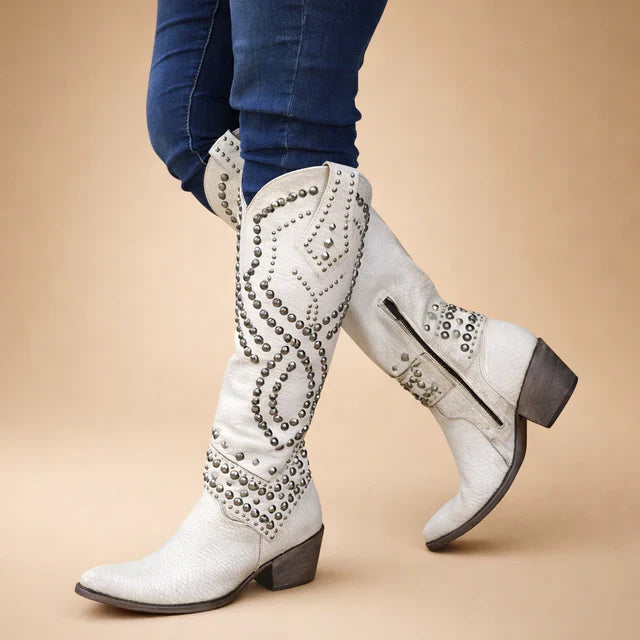 Full view of women's black knee-high cowboy boots featuring vintage stud embellishments.