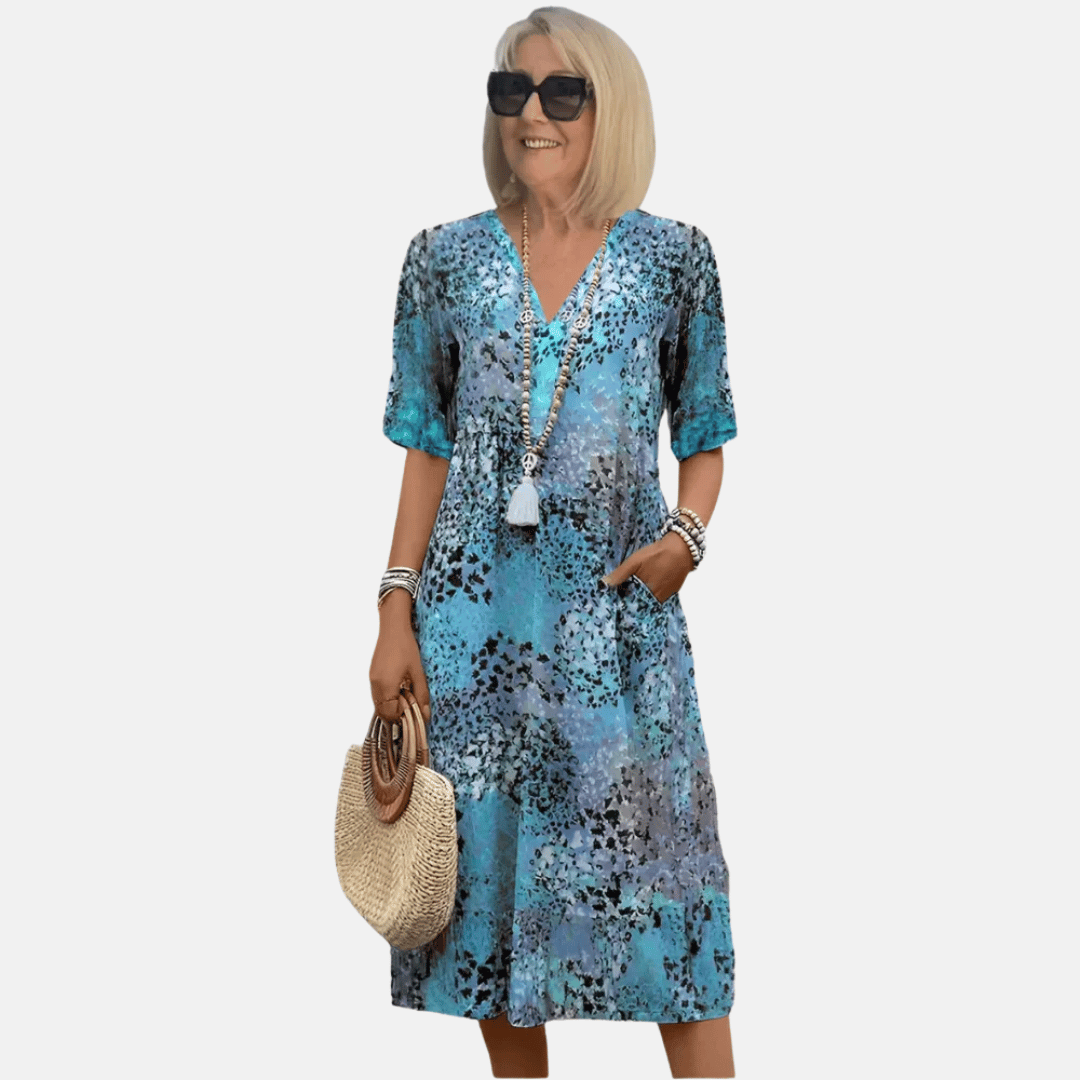 Flowy women's casual summer dress with a v-neck, short sleeves, and an a-line silhouette. Ideal beach or vacation wear.
