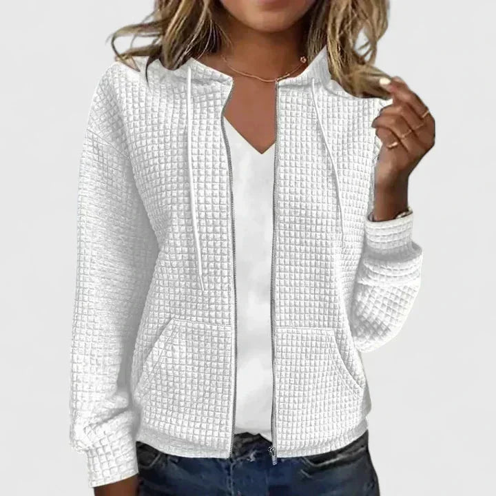 Woman modeling a relaxed-fit waffle-knit hooded cardigan, full-zip front, with handy pockets for convenience.