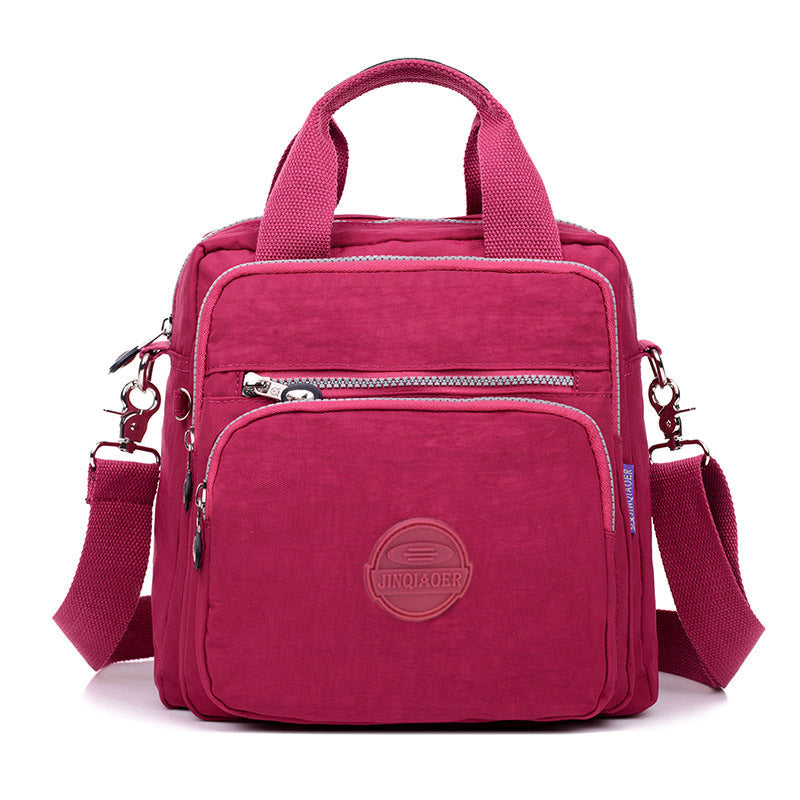 Organized women's water-resistant crossbody bag with multiple compartments for daily essentials.