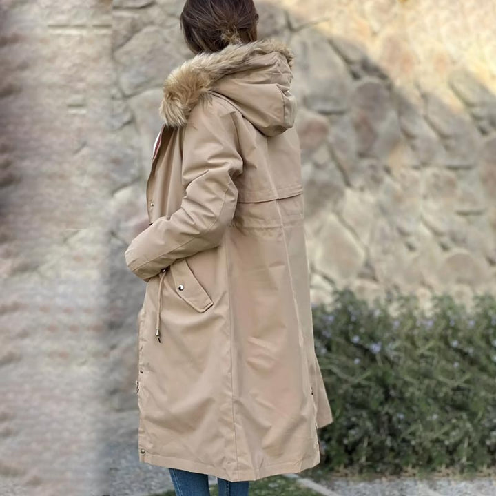 Model wearing a fashionable women's waterproof hooded jacket for outdoor travel.