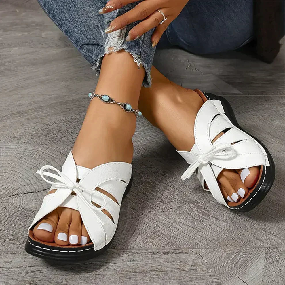 Heeled wedge sandals for women with a comfortable open-toe design & decorative knot detail; ideal summer footwear.