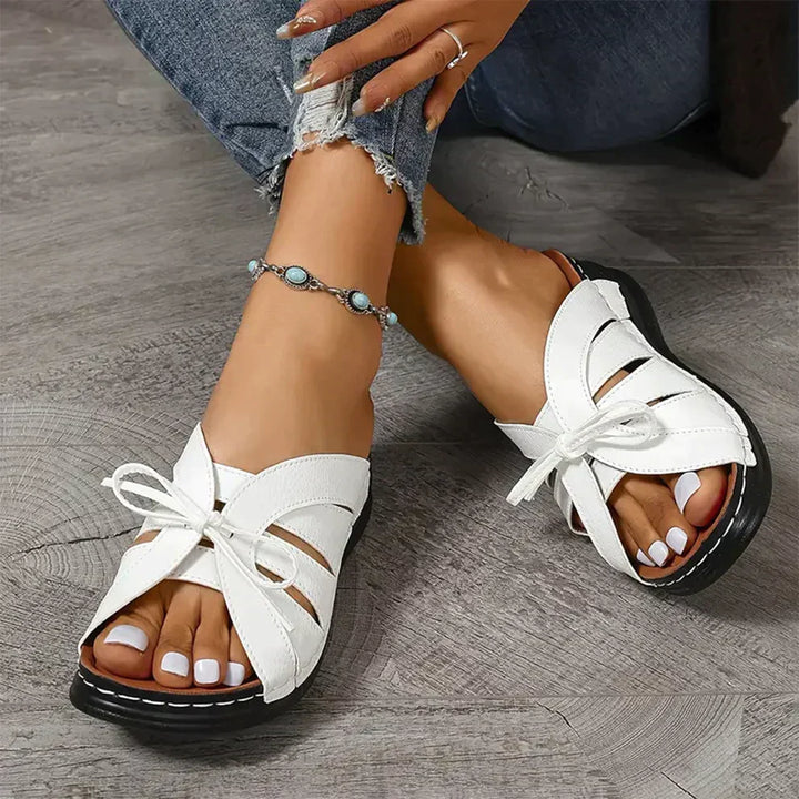 Heeled wedge sandals for women with a comfortable open-toe design & decorative knot detail; ideal summer footwear.