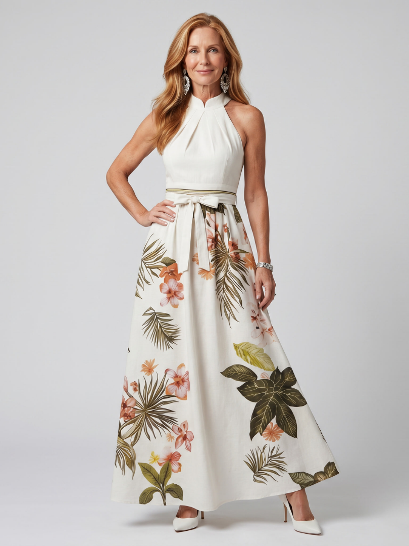 Women's white draped halter maxi dress with botanical panels. Elegant summer fashion for special occasions.