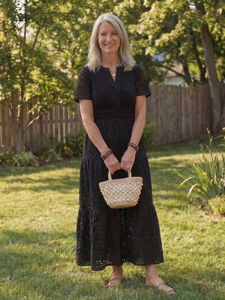Close-up of a women's eyelet midi dress, showcasing tiered layers and short sleeves.