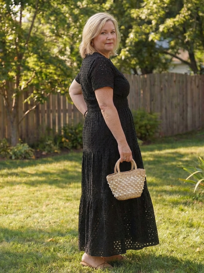 Full-length view of a women's comfortable eyelet tiered midi dress with short sleeves for summer.