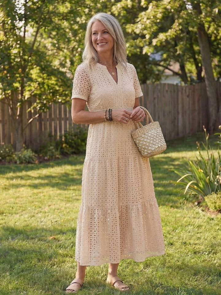 Breathable eyelet fabric on a women's tiered midi dress, designed with comfortable short sleeves.