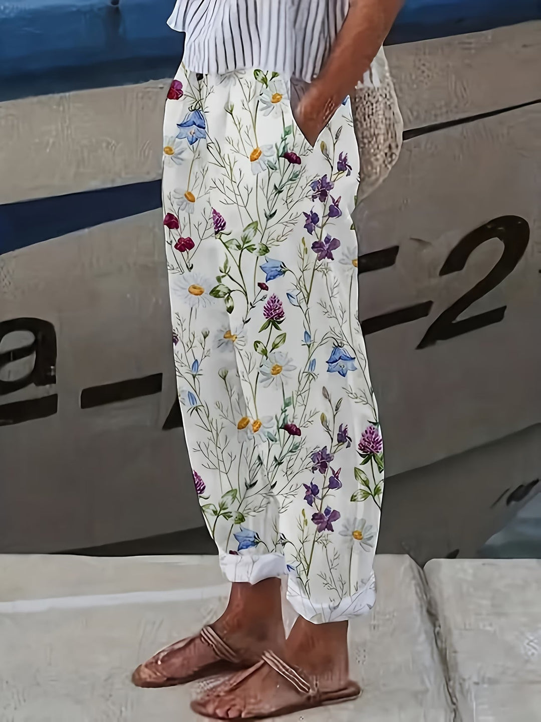 Women's white floral wide-leg summer pants with an elastic waist, perfect for comfortable vacation wear or chic casual style.
