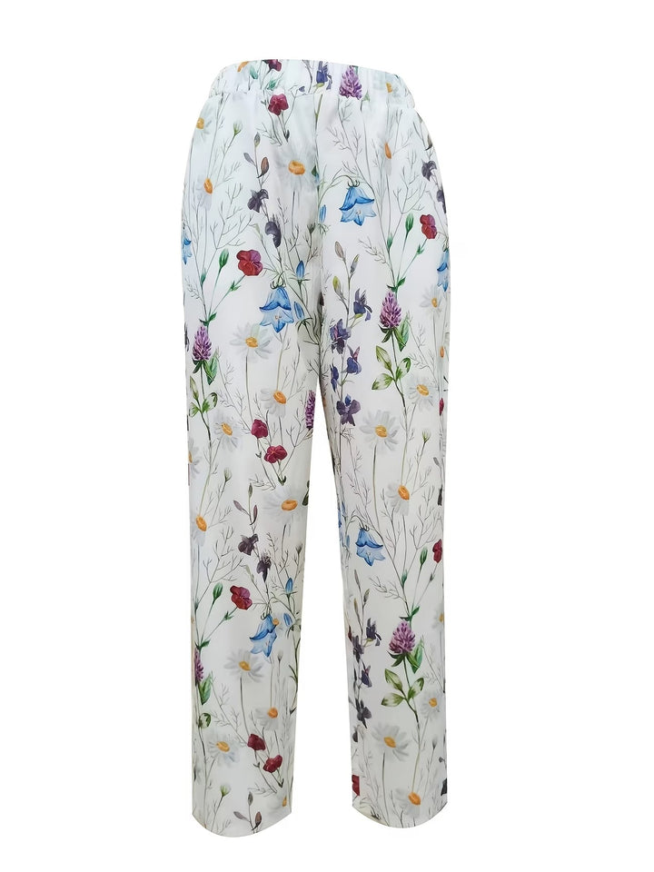 Chic white women's pants with a vibrant floral print and wide-leg design, ideal for summer fashion and comfort.