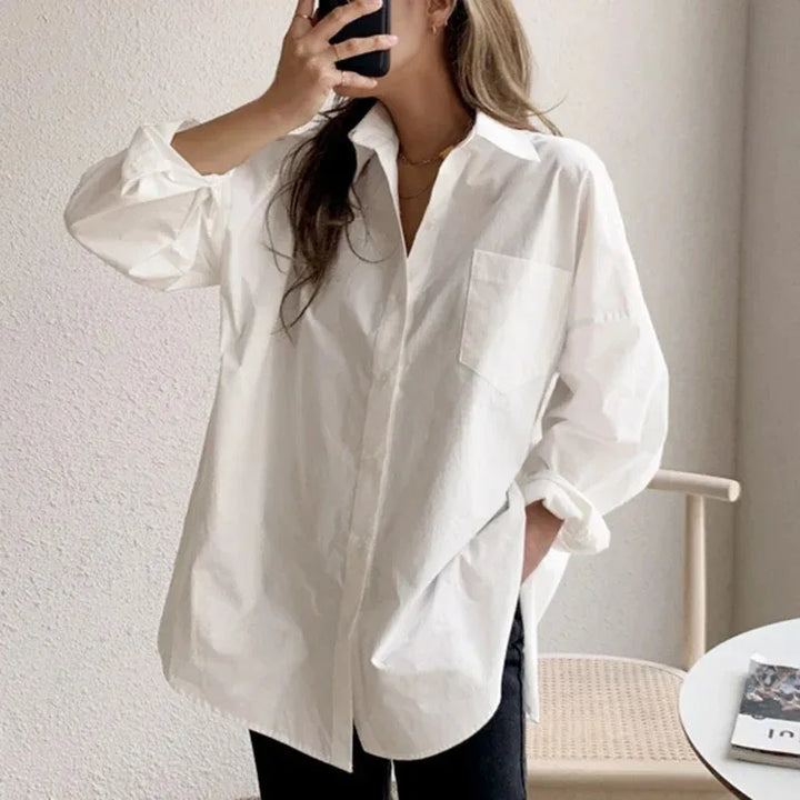 Casual elegant women's oversized white button down blouse. Long sleeve, relaxed fit, versatile wardrobe top.