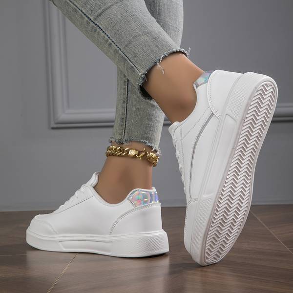 Fashionable white women's sneakers featuring subtle gold and silver metallic accents for a modern look.