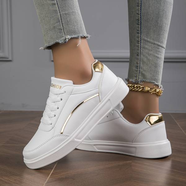 Clean white women's trainers with elegant metallic details, ideal for comfortable and stylish everyday wear.