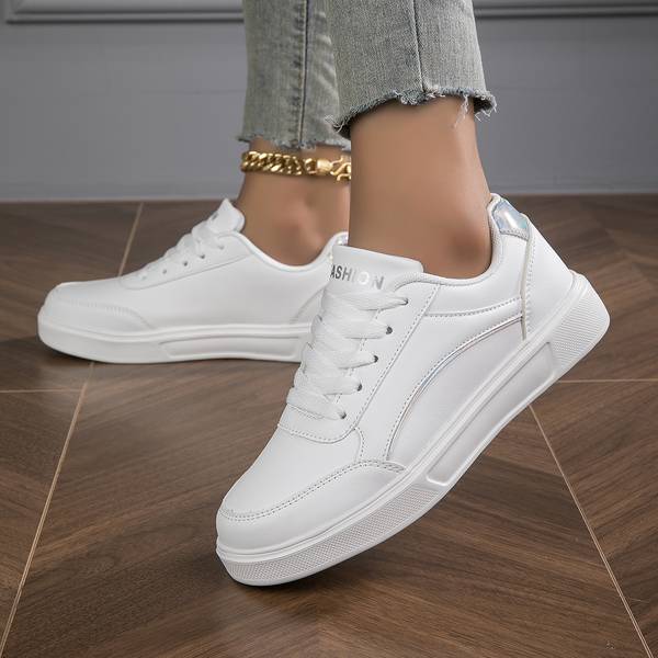 Stylish white women's trainers with metallic accents, versatile for smart casual outfits and comfort.