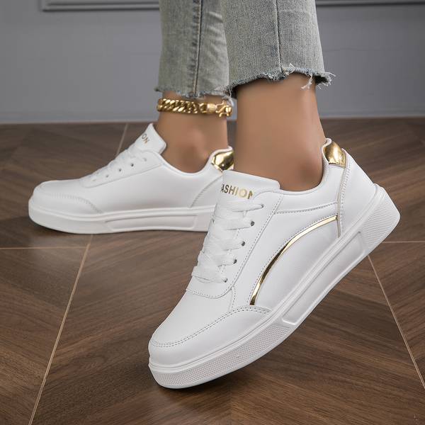 Elegant white metallic accent trainers for women, combining comfort with a sleek, modern footwear design.