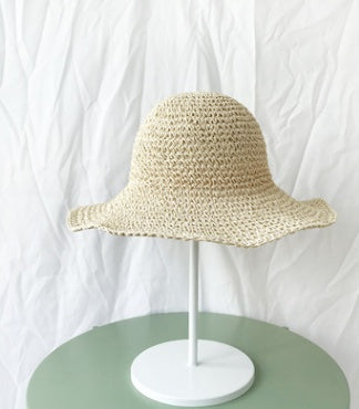 Stylish women's crochet straw bucket hat with wide brim, perfect for beachwear.