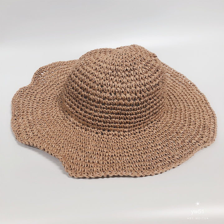Hand-crocheted women's straw bucket hat with wide brim, perfect for summer beach style.