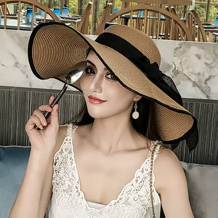 Summer fashion accessory: a women's wide brim straw hat with a decorative bow.