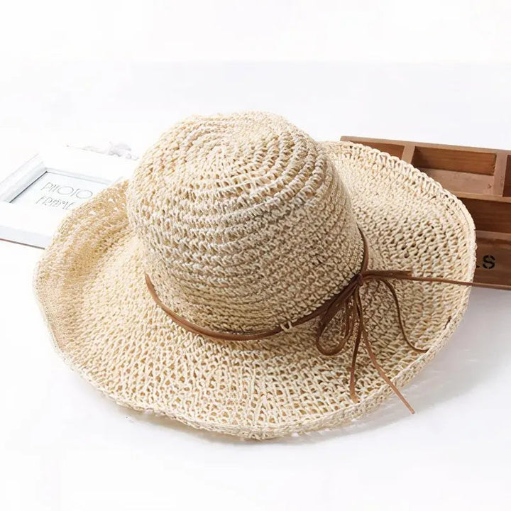 Elegant women's straw sun hat with wide brim, perfect for summer fashion and UV sun protection.