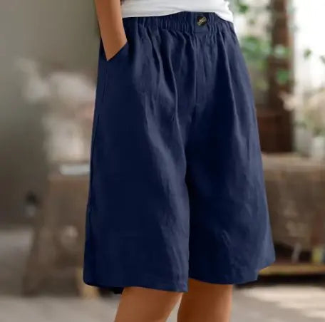 Woman wears relaxed fit wide leg high waist elastic shorts, perfect for comfortable casual summer day wear.