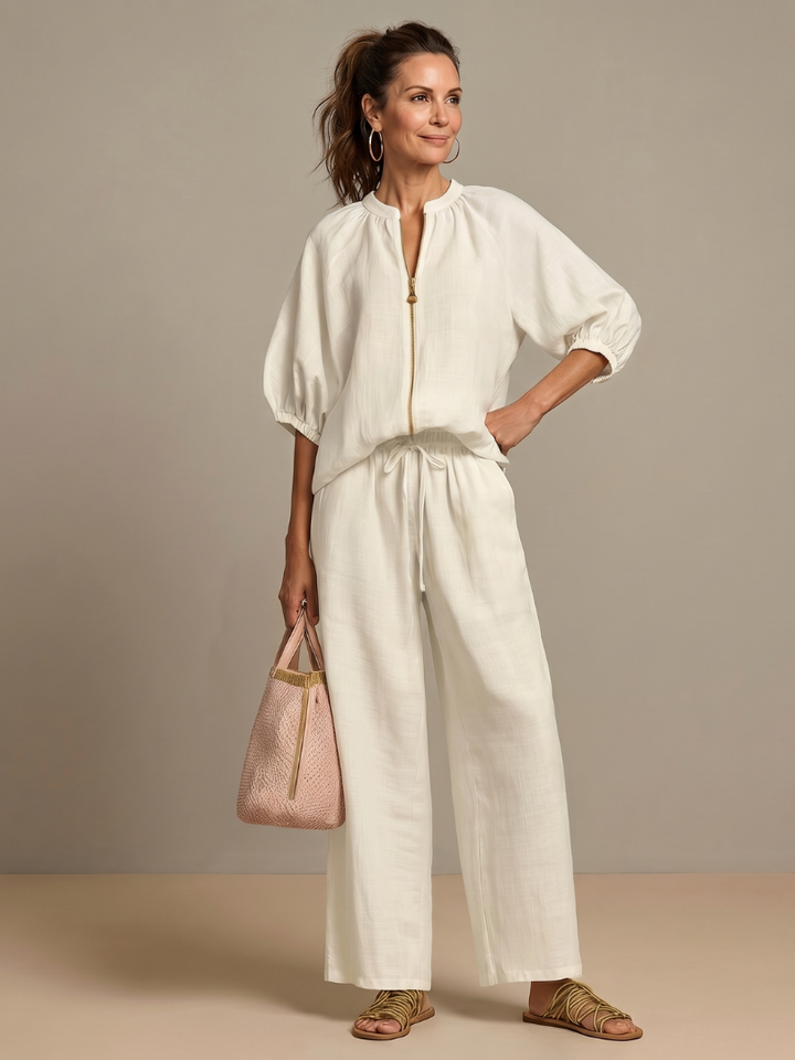 Close-up of zip front blouson top with stand neckline, from a women's wide leg pant set.