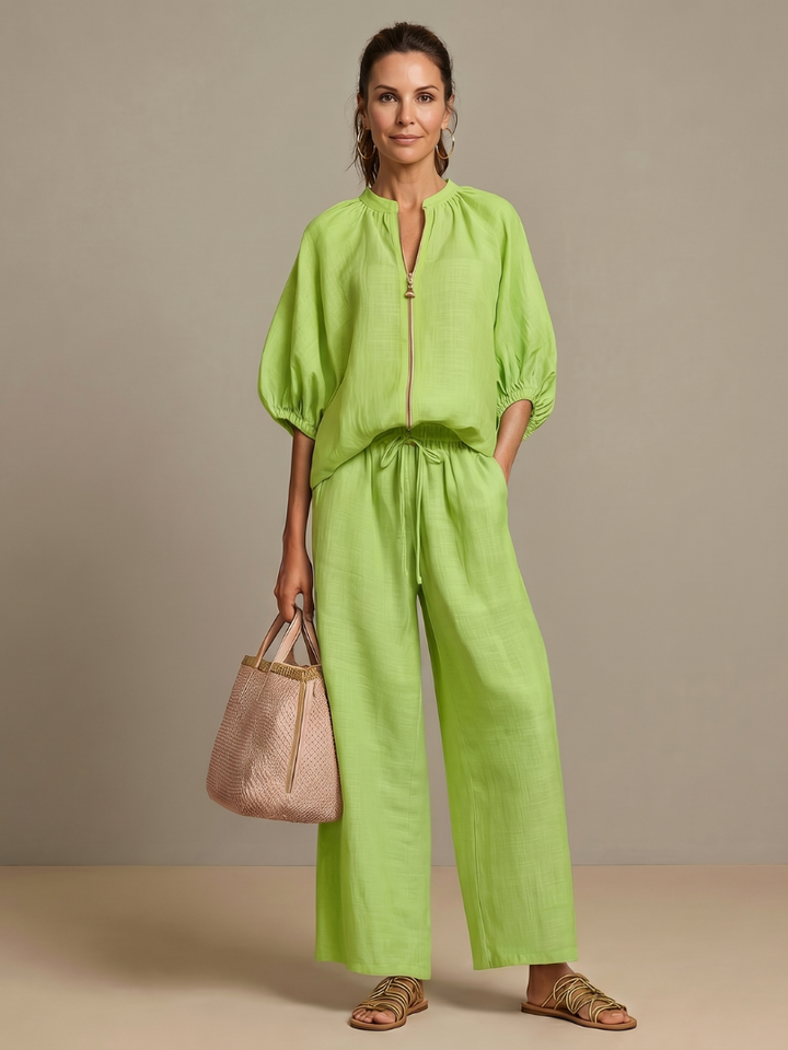 Women's blouson top with zip front & stand neckline, part of a comfortable wide leg pant set.