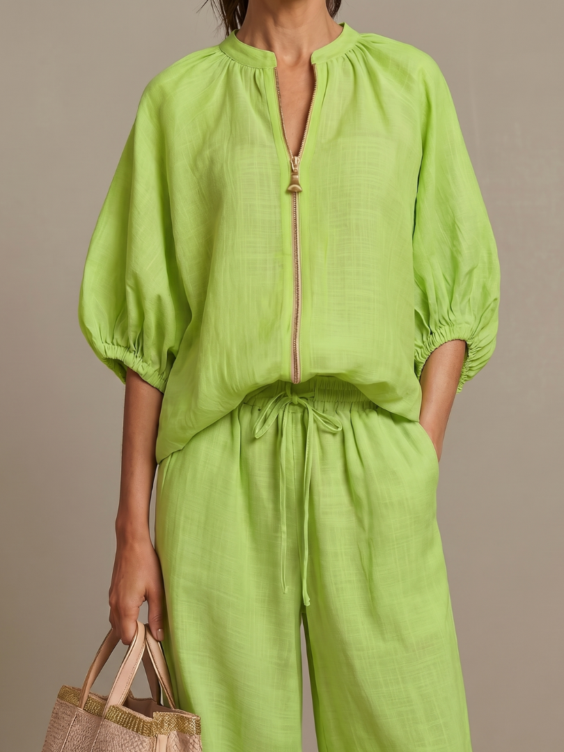 Model wearing a women's zip front blouson top & wide leg pant matching set, looking stylish.