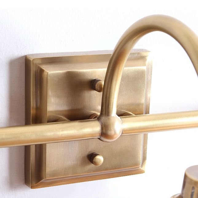 Hardwired antique brass indoor wall lamp, elegant design with a clear glass shade for ambient light.