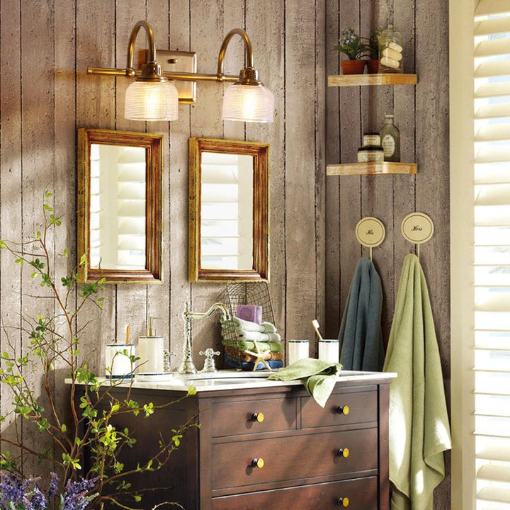 Zorlo elegant indoor wall light, antique brass with a clear glass shade for ambient lighting.
